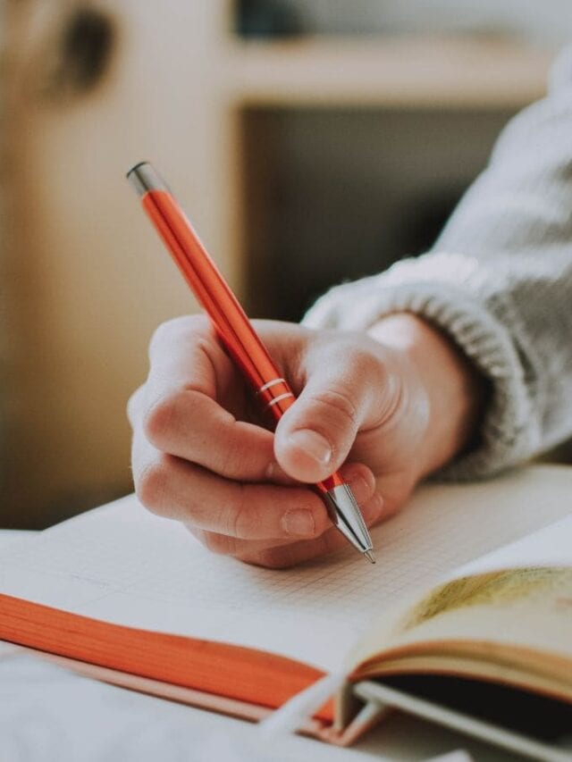 pessoa escrevendo no caderno enquanto estuda para concurso